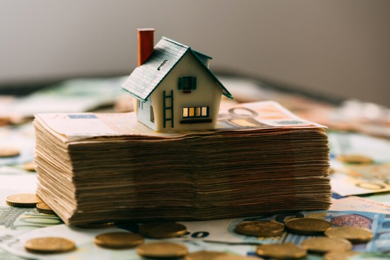 House model on cash stack closeup